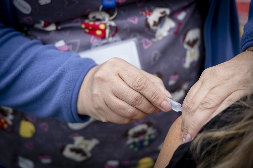Administración de vacuna contra influenza a persona en su brazo
