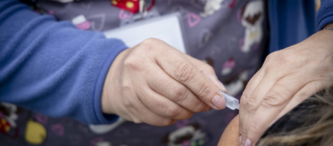 Administración de vacuna contra influenza a persona en su brazo